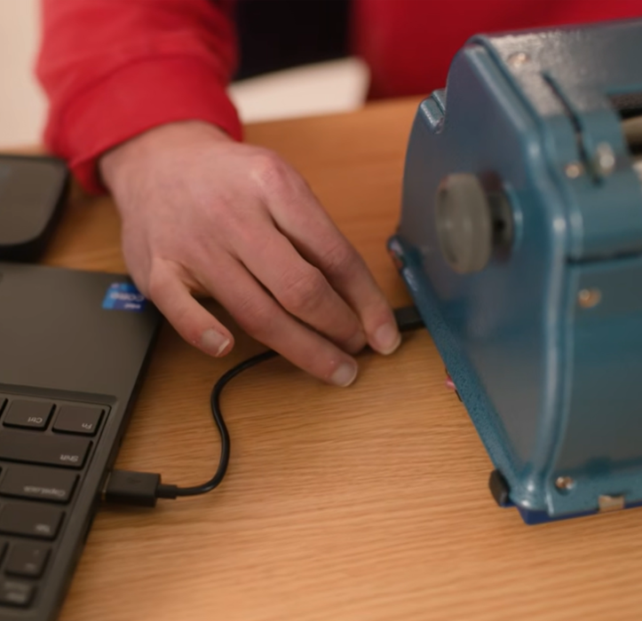 Perkins Braille Bloom connected to a laptop via USB cable